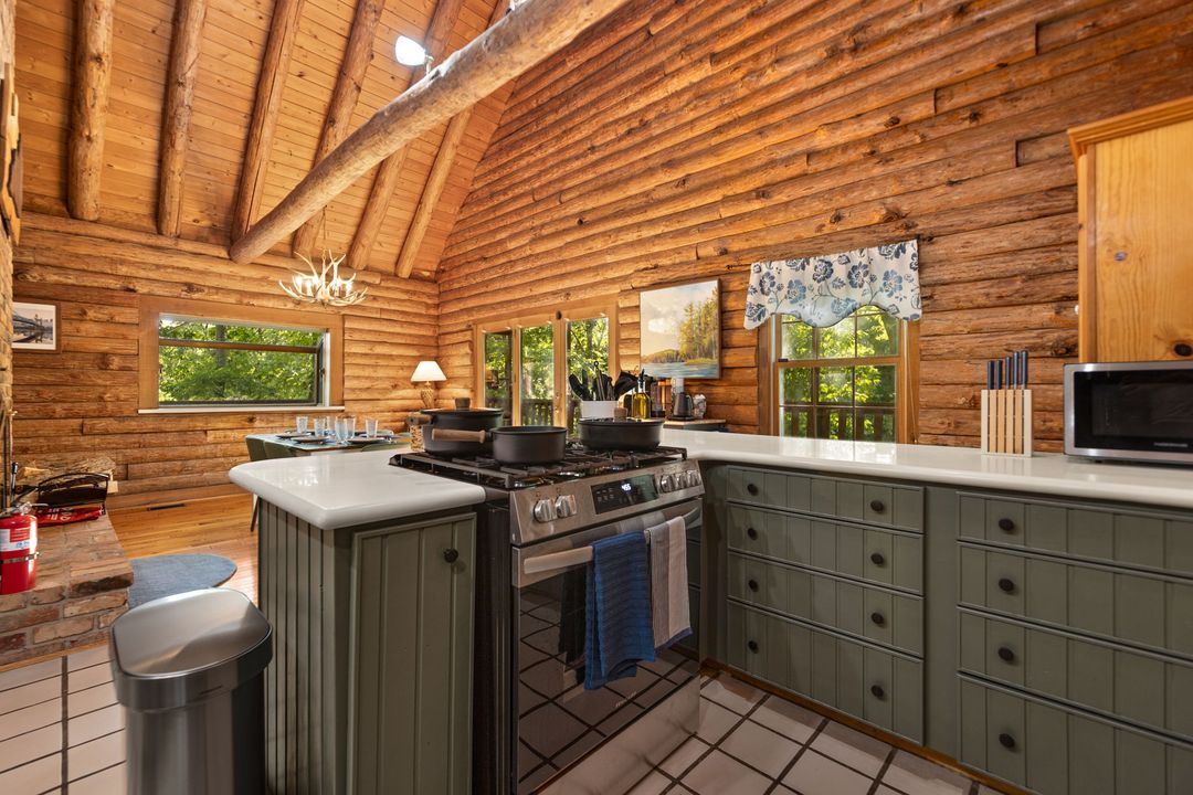 Kitchen with green cabinetry and a wood ceiling