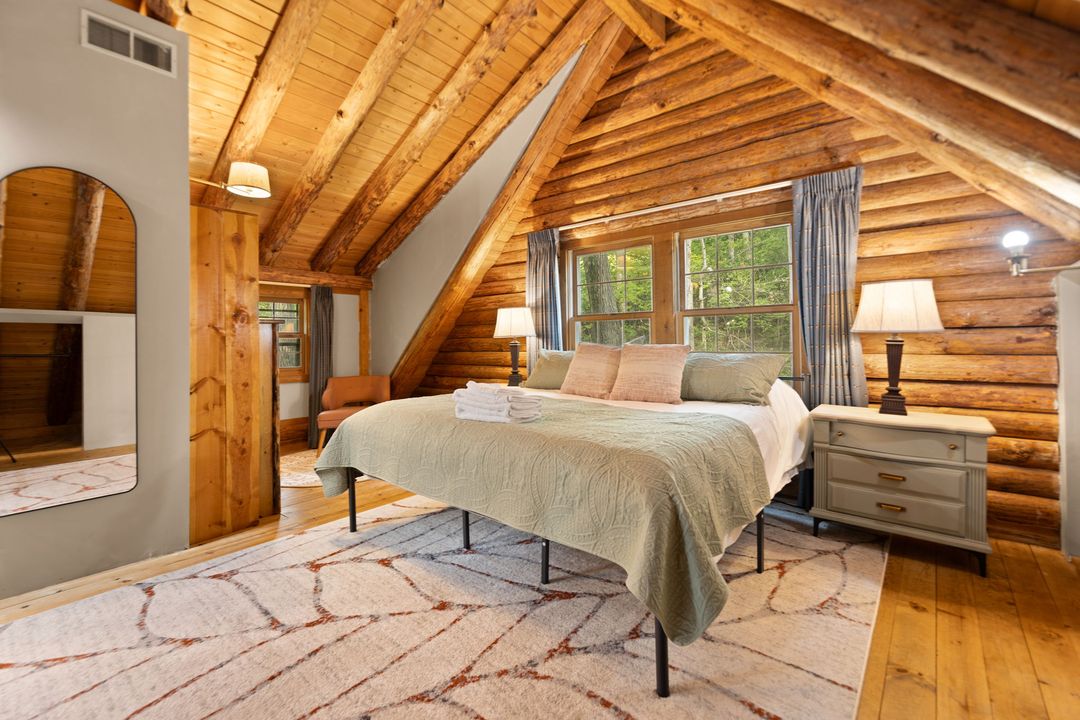 Loft primary bedroom under the vaulted wood ceiling